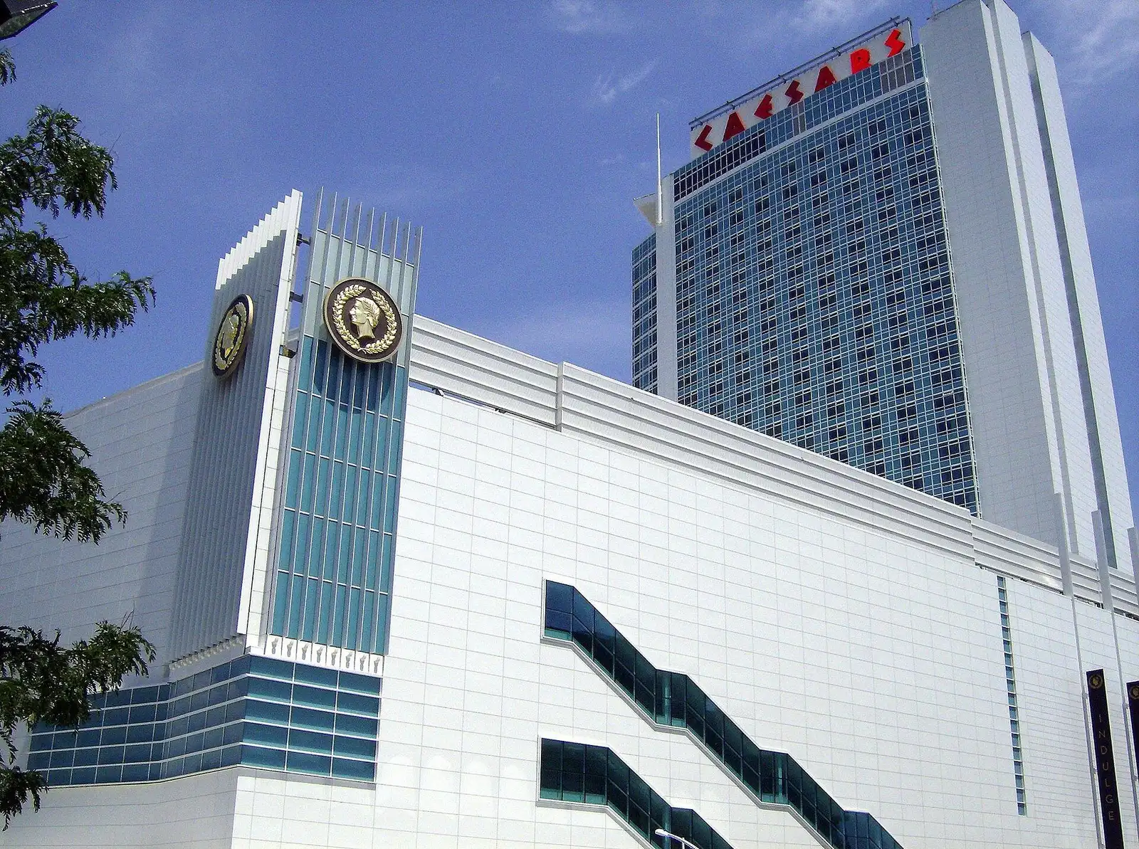 Caesars Windsor: gilded laurel medallions on the white casino facade, with the signed hotel tower behind — Caesars Windsor