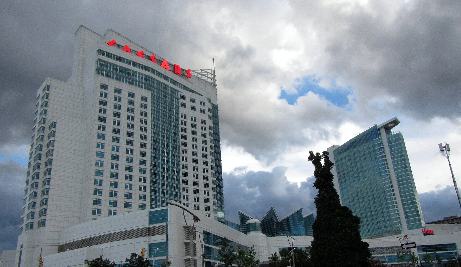 The Caesars Windsor casino complex in Windsor, Ontario: the white hotel tower with its rooftop sign, the glass-roofed pavilion and the glass hotel tower — Caesars Windsor