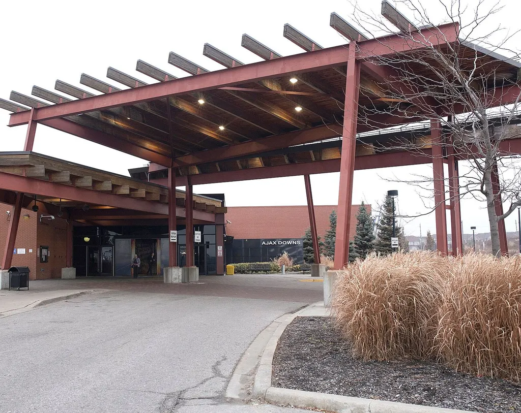Driveway approach to the covered main entrance at Casino Ajax, with the Ajax Downs sign on the facade (cropped) — Casino Ajax