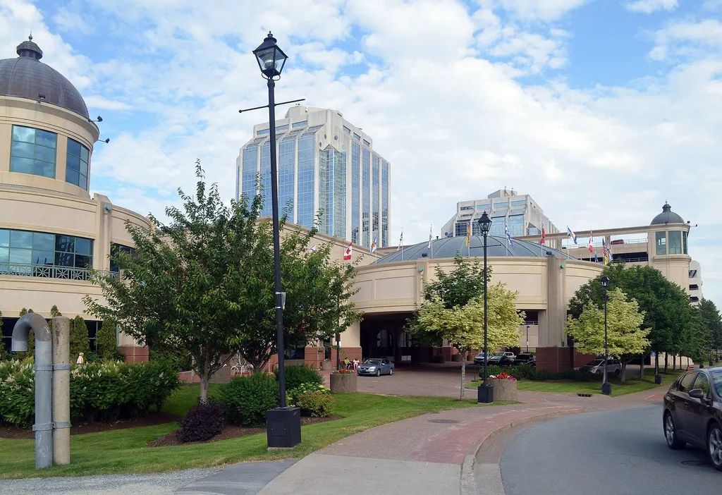 Casino Nova Scotia in Halifax: copper-domed rotundas flank a glass-roofed entrance drive, with downtown office towers behind. — Casino Nova Scotia Halifax