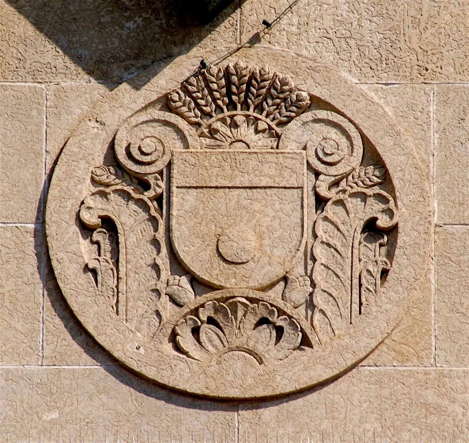 Carved stone roundel with a shield and wheat sheaves on the former Union Station, now Casino Regina — Casino Regina