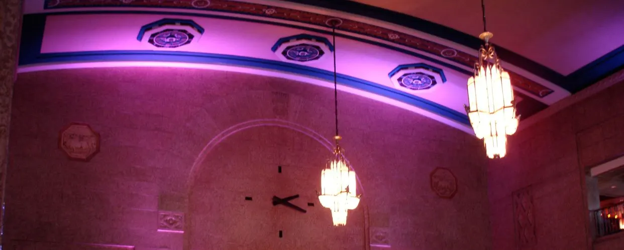 Art Deco chandeliers, a large wall clock and the ornamental ceiling band of the former Union Station concourse at Casino Regina (cropped). — Casino Regina
