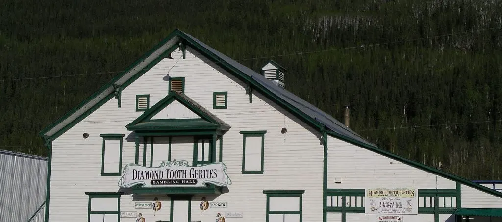 The white clapboard gable of Diamond Tooth Gerties Gambling Hall, with its green trim and name sign, in Dawson City, Yukon — Diamond Tooth Gerties Gambling Hall