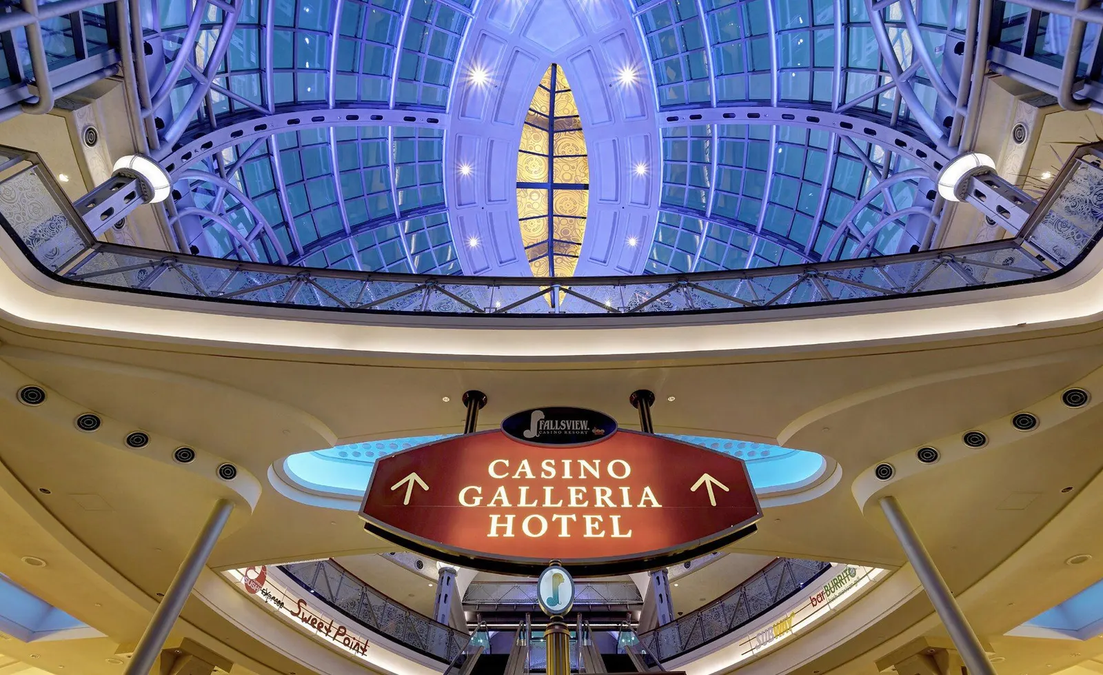 Glass dome above the rotunda inside Fallsview Casino Resort, with a hanging sign pointing to the casino, galleria and hotel — Fallsview Casino Resort