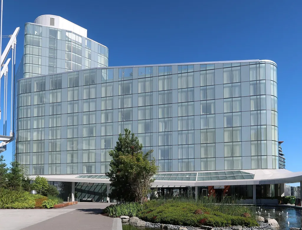 The glass hotel towers of Parq Vancouver above the casino podium, seen across the pond from the complex's elevated park deck — Parq Casino